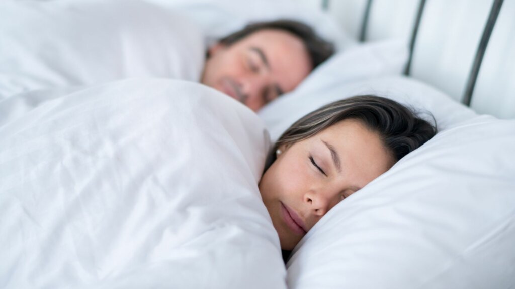 Mann und Frau liegend schlafend im Bett