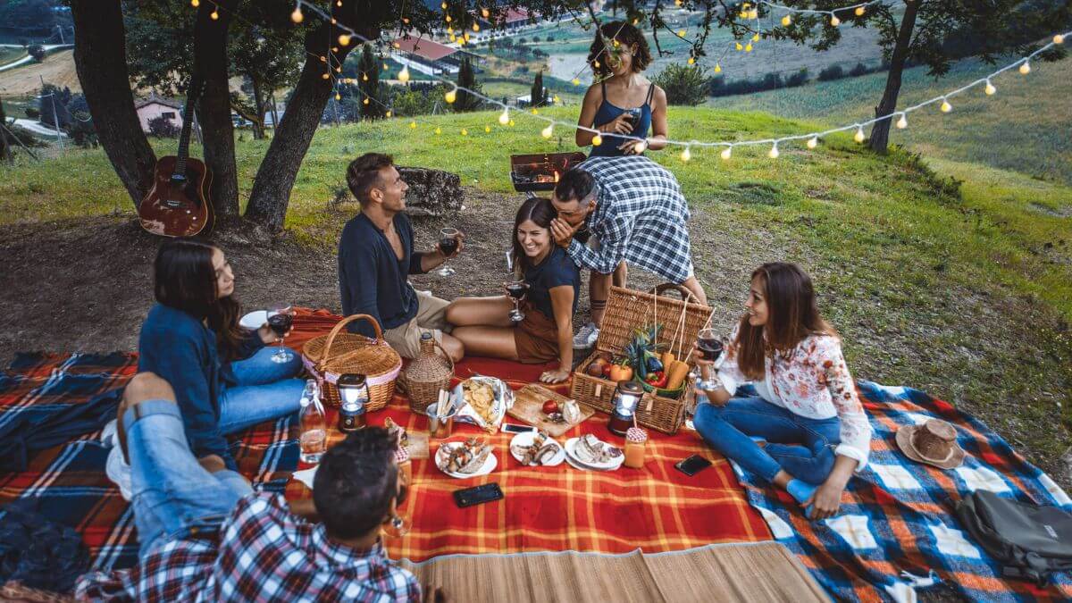 Freunde picknicken in der Abenddämmerung - Beziehung zu anderen Menschen