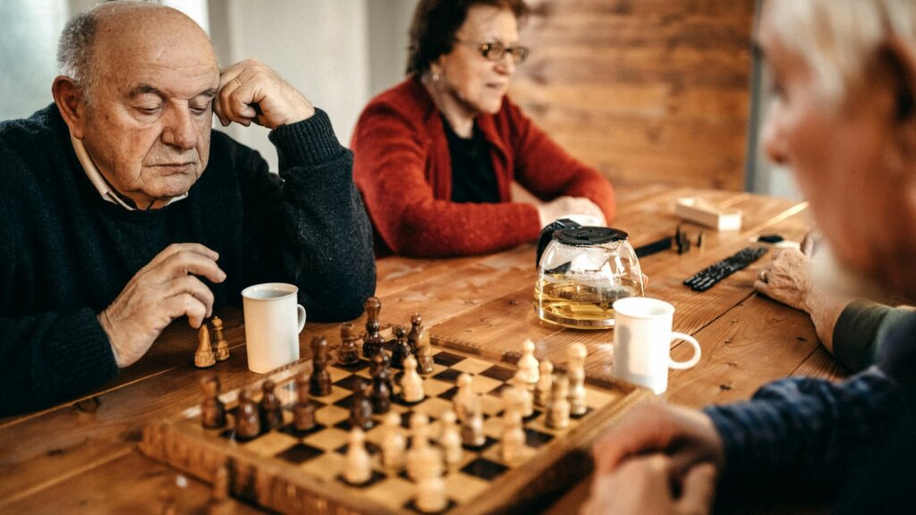 Zwei Männer sitzen am Tisch und spielen Schack, um schneller zu denken