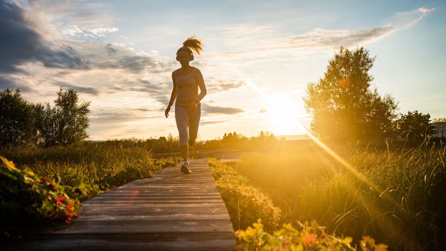 Frau joggt im Morgenrot - gesunder Lebensstil