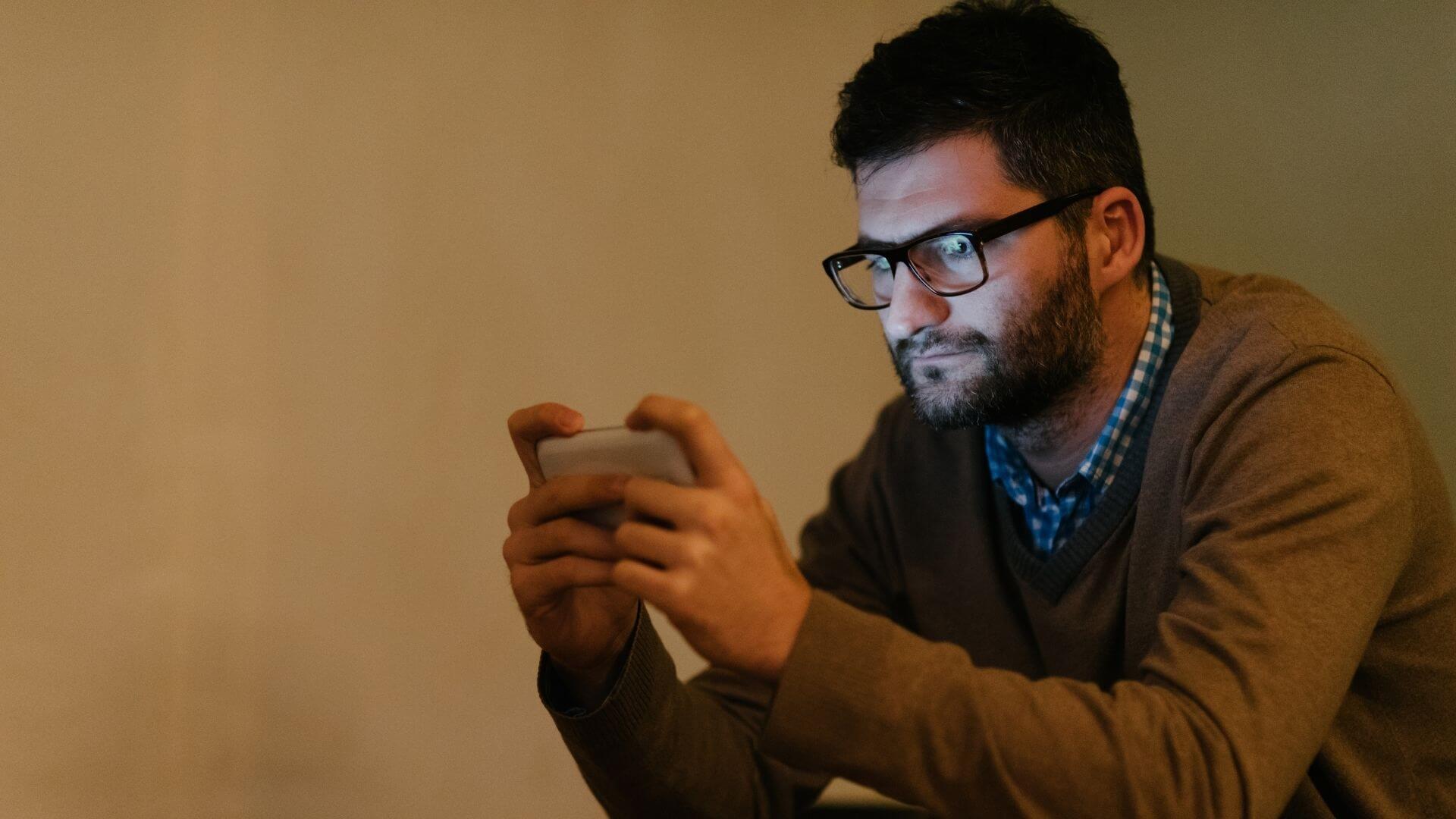 Mann spielt mit Handy am Abend - Blaulicht